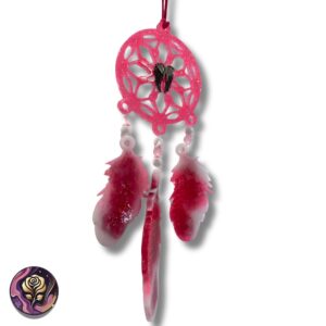 Close-up of hot pink glitter dream catcher with resin feathers, butterfly charm, and boho beads hanging against a neutral wall