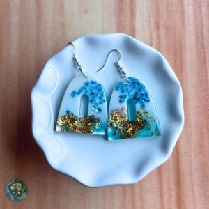 Handmade blue arch resin earrings with gold heart flakes and star accents, displayed against a white background