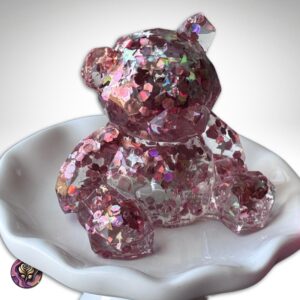 Handmade clear resin bear figurine with pink glitter and star accents, standing on white background