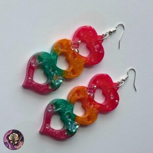Handmade rainbow resin earrings with triple heart drops in red, yellow, and green, featuring butterfly accents and heart cutouts