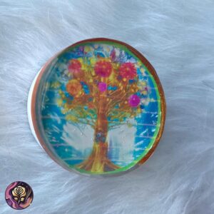 Round resin pop socket with Tree of Life design in a multicolor background, handmade and nature-themed.
