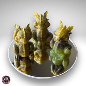 Handmade resin Hear No Evil dragon figurines in lime green, black, and gold on reflective mirrored surface – fantasy decor set of three.