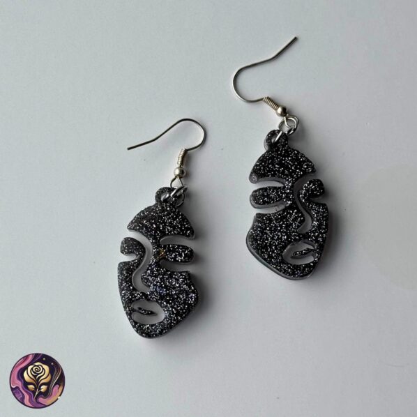 Two-Faced Glitter Resin Earrings with black and silver sparkle and abstract face design