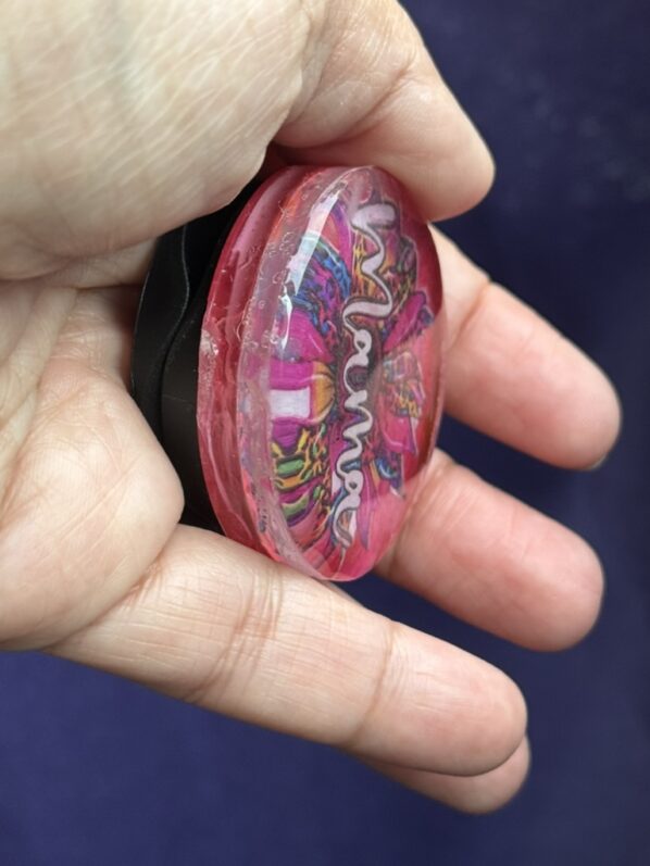 Angled side view of the grip held in hand, showing resin thickness and sparkle detail