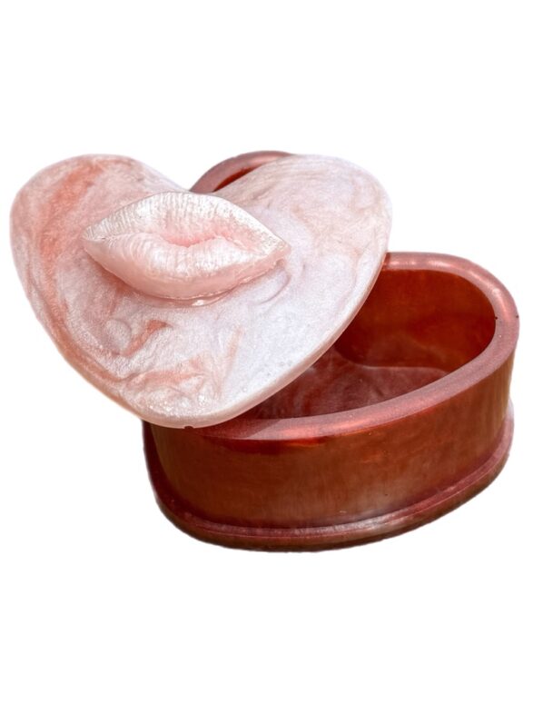 Heart-shaped resin trinket box with pearly lip lid in pink and red tones