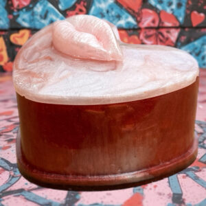 Heart-shaped resin trinket box with pearly lip lid in pink and red tones
