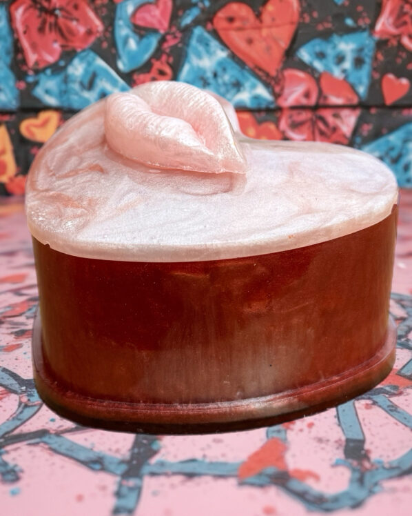Heart-shaped resin trinket box with pearly lip lid in pink and red tones