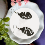 Black glitter resin earrings on a dish — bold, edgy, and handmade