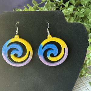 Handmade pinwheel earrings with glittery color blend on navy background